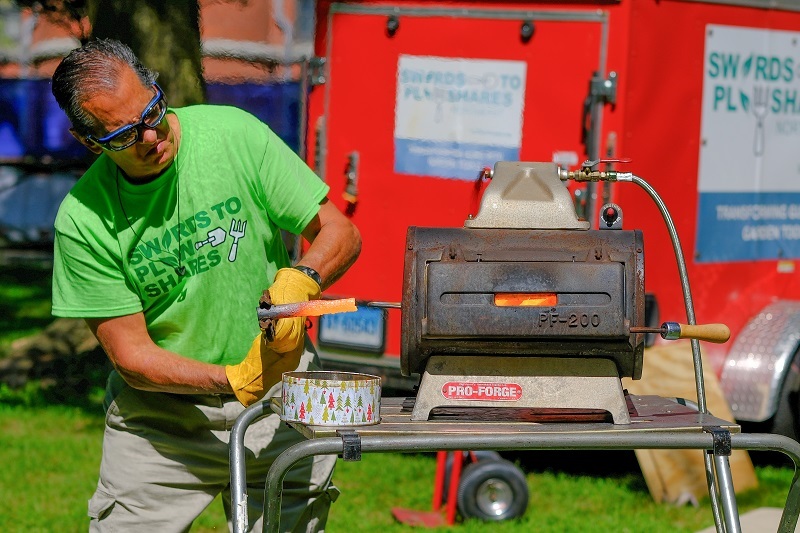 Person using blacksmithing to turn gun parts into garden tools.